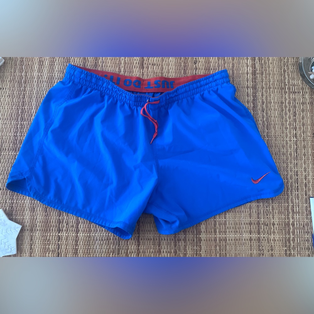 Nike bright blue athletic shorts with orange accents